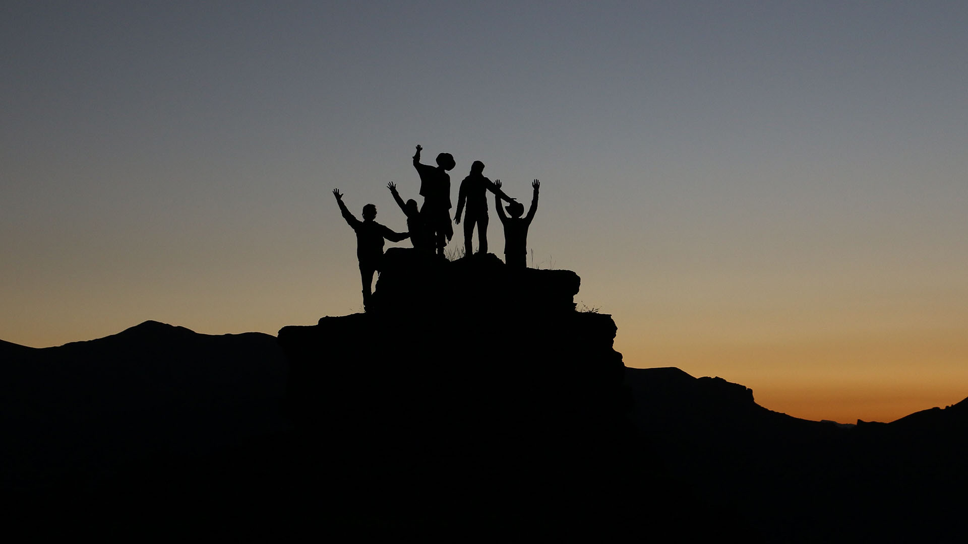 group silhouette on mountain